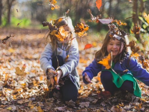 photo of children playing with dry leaves