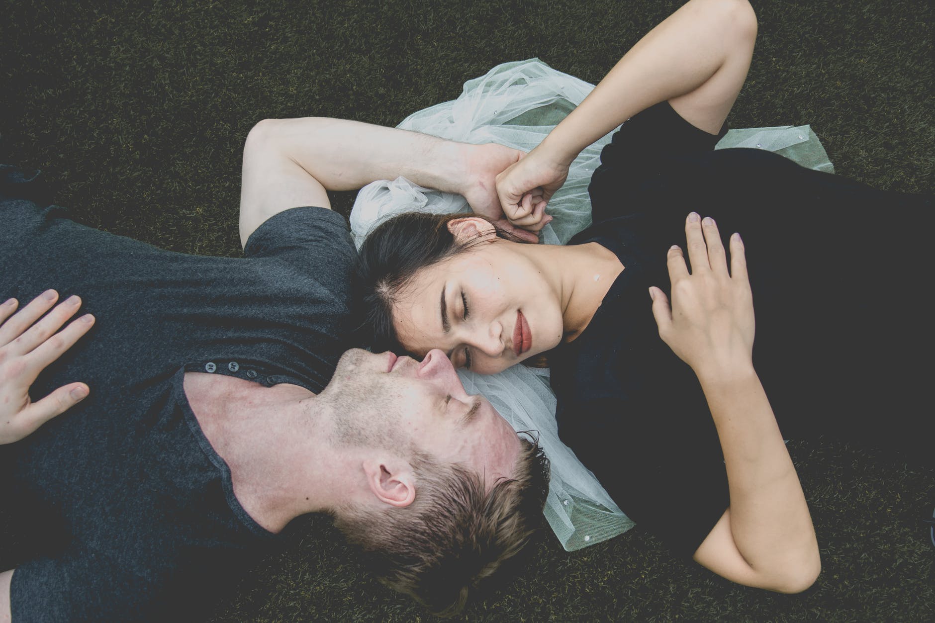 man and woman lying on ground posing for photo